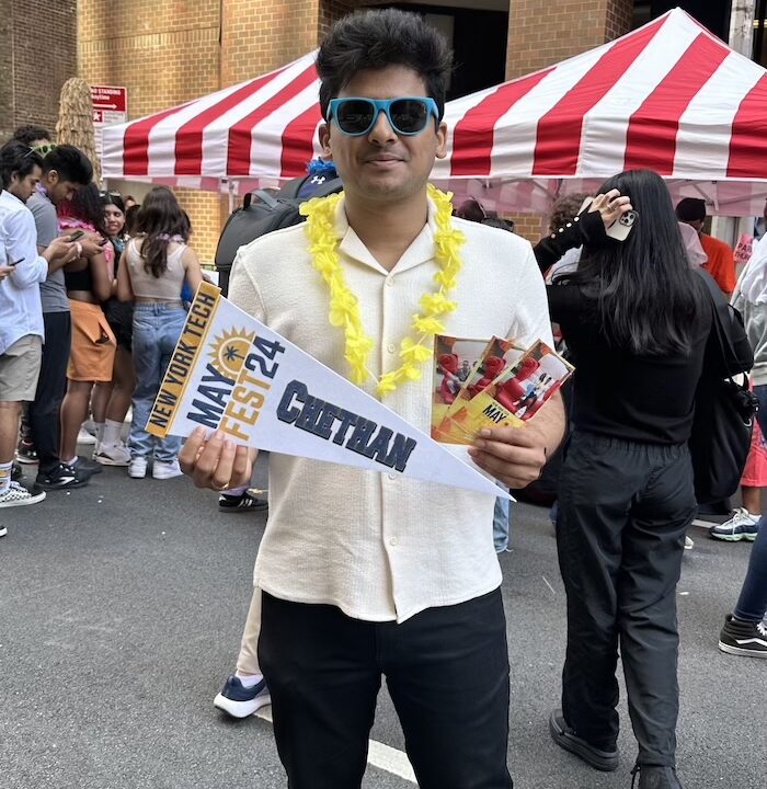 Student holding New York Tech Mayfest Swag