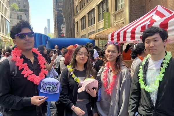 Four students posing for photo one holding a graffiti hard they made