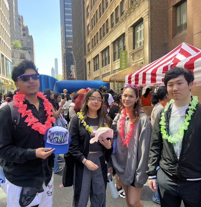 Four students posing for photo one holding a graffiti hard they made