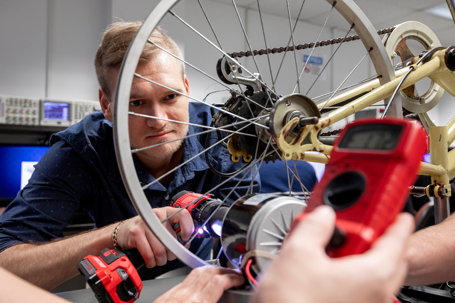 In one of New York Tech's applied classrooms, two Mechanical Engineering, B.S. students learn about motion, force, and gravity using a bicycle wheel and monitoring tool.