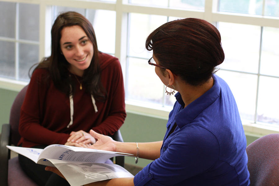 A school counselor presenting a brochure to a student.