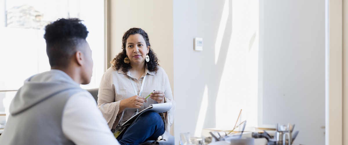 A faculty member in the School Of Health Professions talks to a Mental Health Counseling, M.S. student.