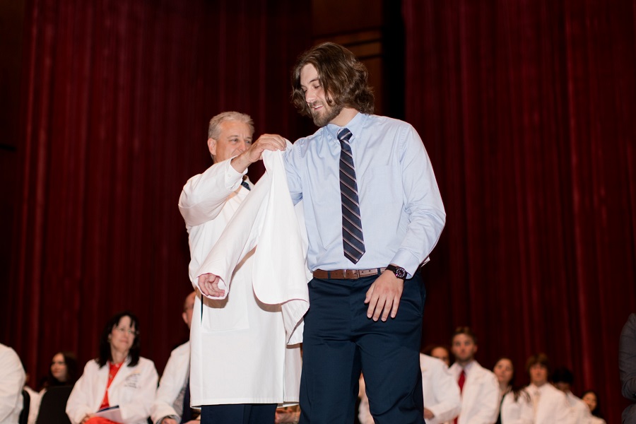 NYITCOM-Arkansas student Nathanial Lamb is coated by his father, Trent Lamb, M.D.