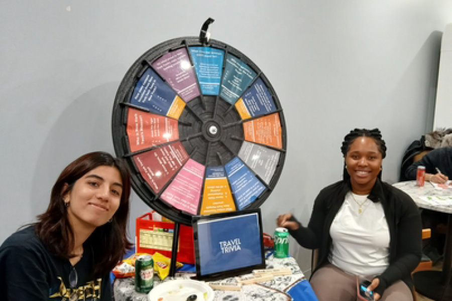 Students sitting by spinning wheel