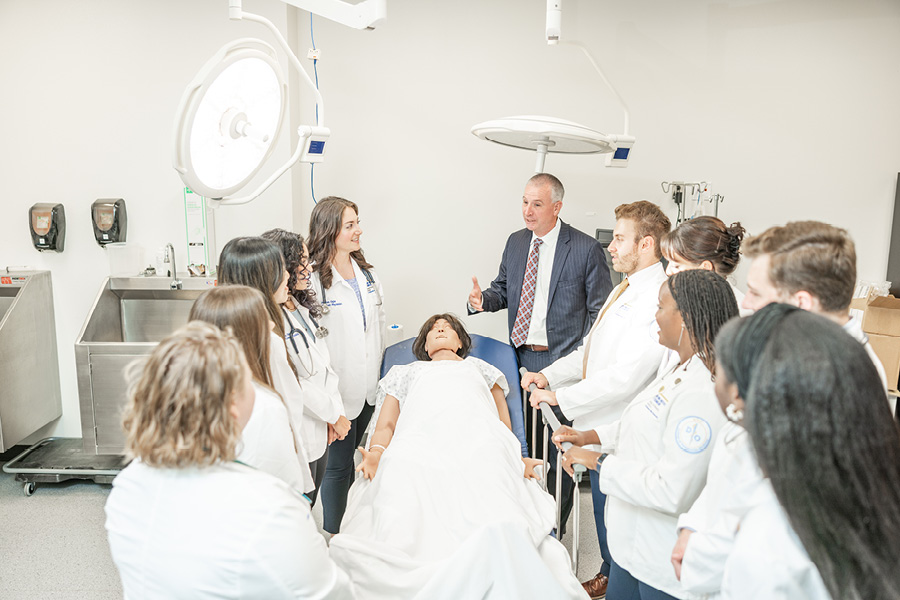 Site Dean Shane Speights teaching students in a medical simulation lab