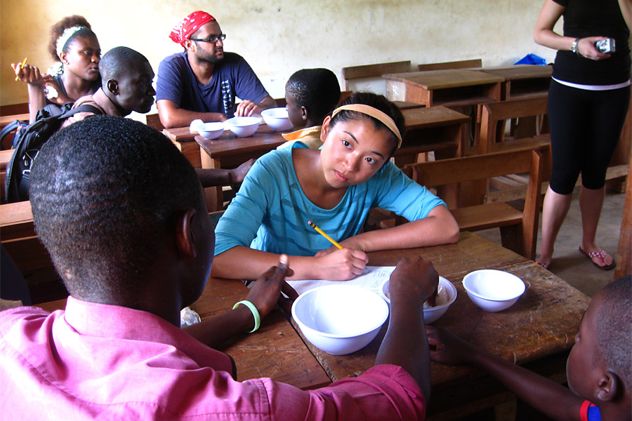 A student studying abroad, taking notes on a wooden table.