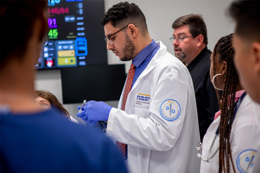 Close up of a medical student surrounded other students and the professor behind them.