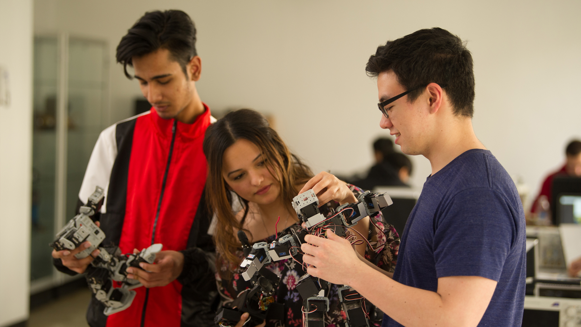 Three students work on a technology project. 