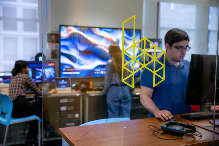 A view through the front glass wall of the HIVE with student working in it. 