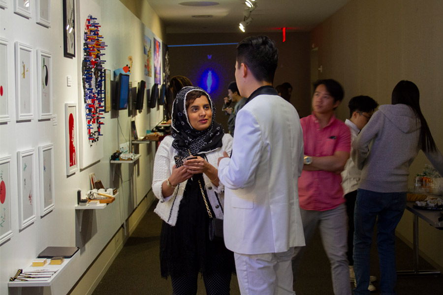 Two people having a discussion in a exhibition gallery. 